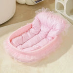Pink pastel pet nest with a padded base, raised sides and decorative lace trim.